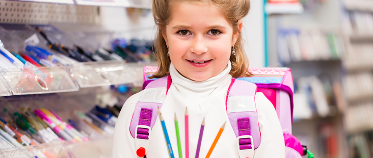 enfant avec ses fournitures scolaires